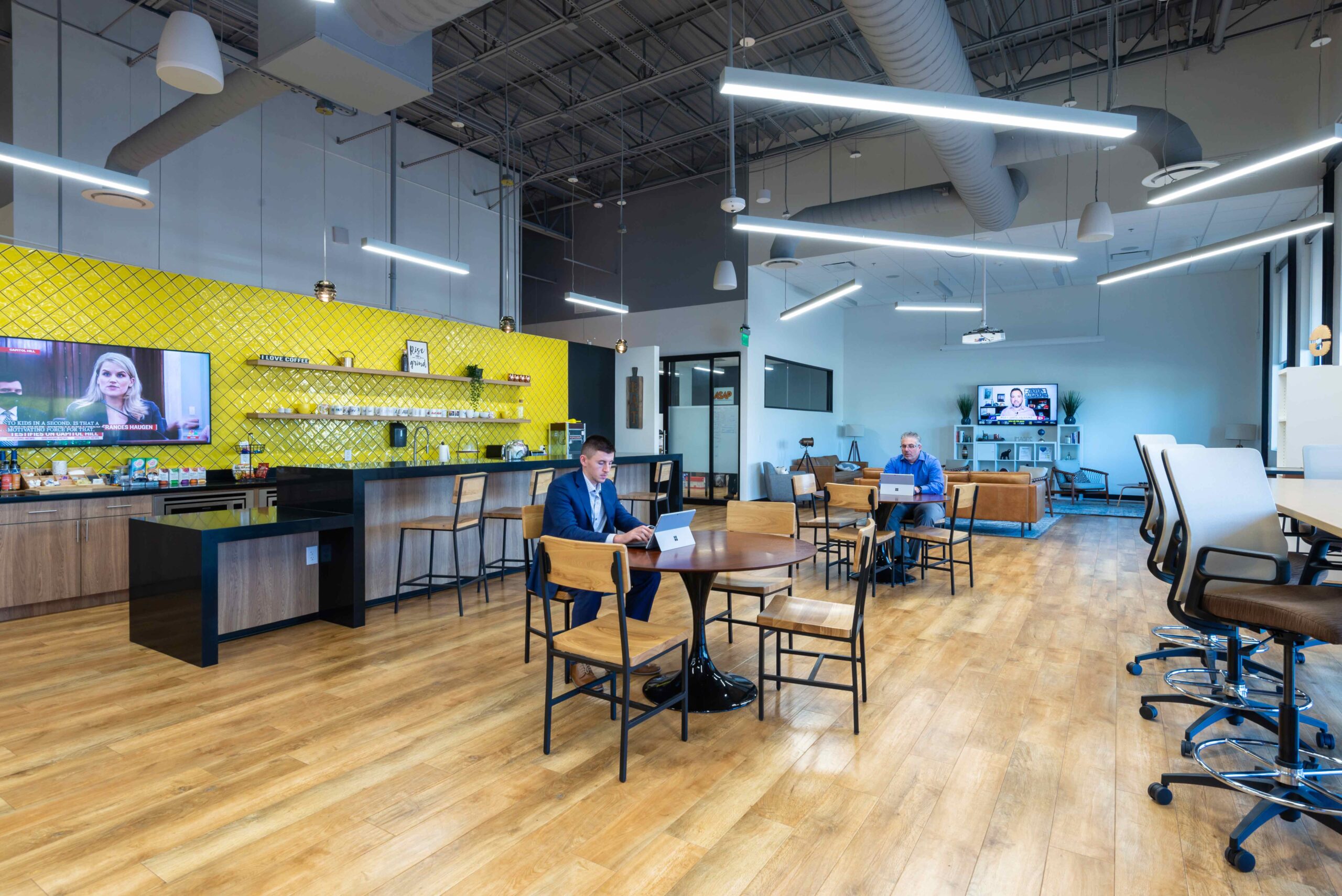 Coworking space in Dallas. Main room has many tables for groups of 4 to meet in a shared office space.