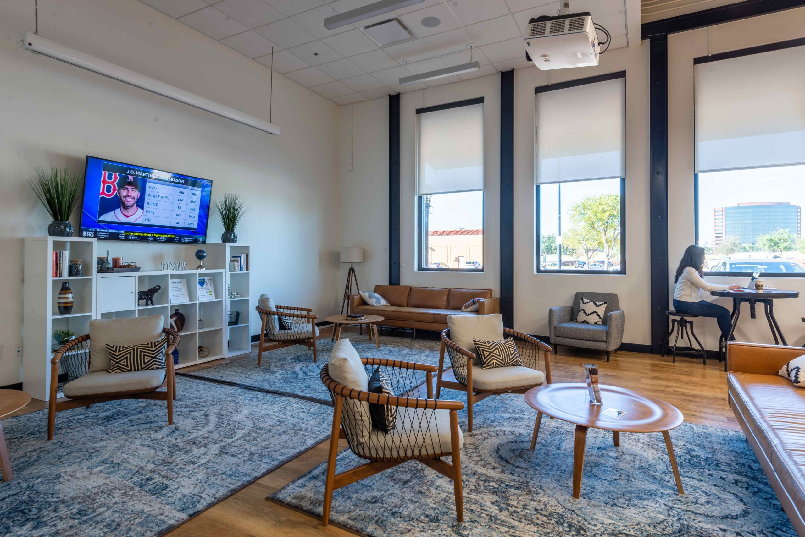 Coworking space in Dallas. Room has a TV, couches, and desk for shared office space.