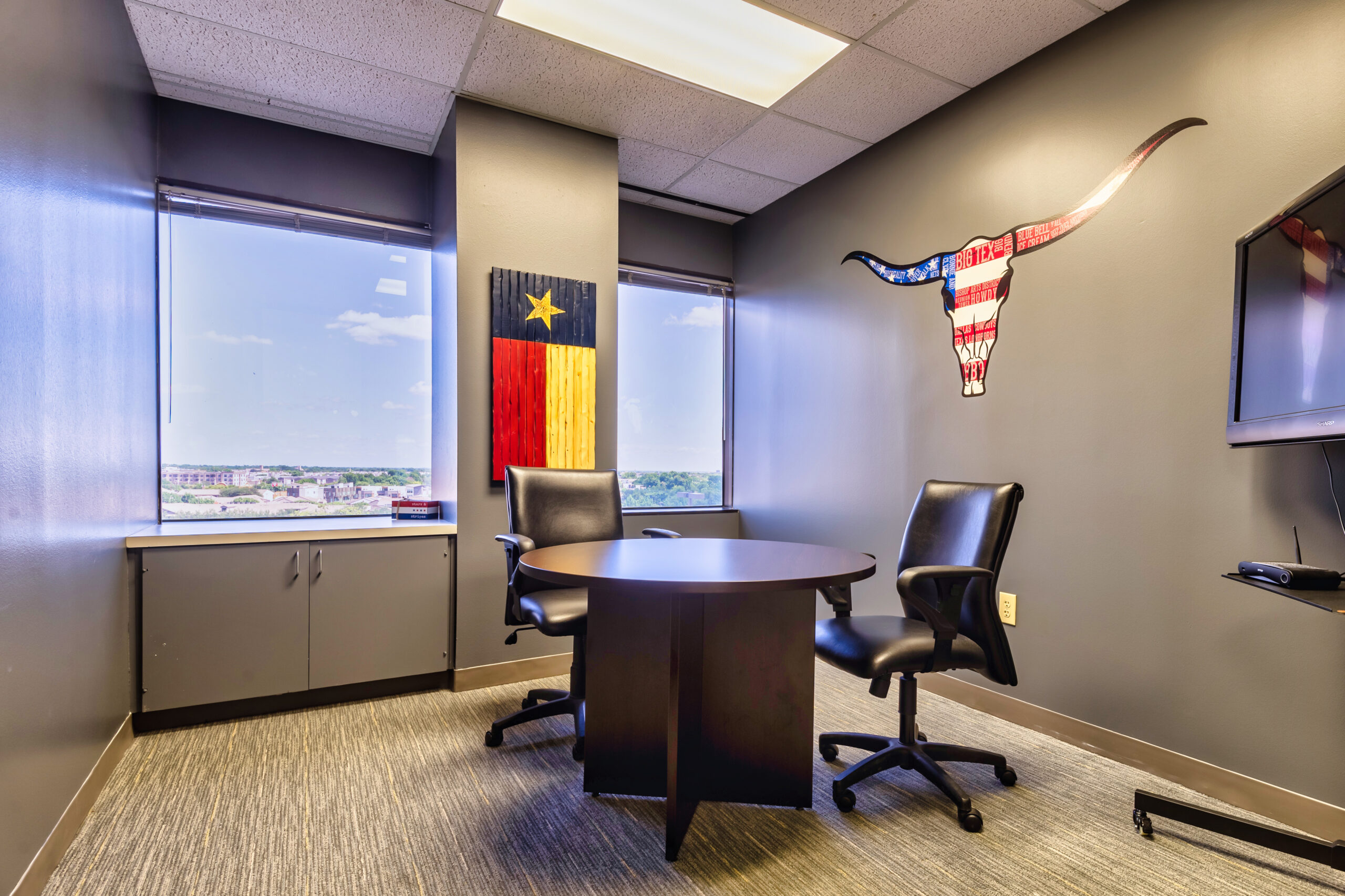Office space for rent in Dallas. Meeting space has large windows, desk and 2 chairs.