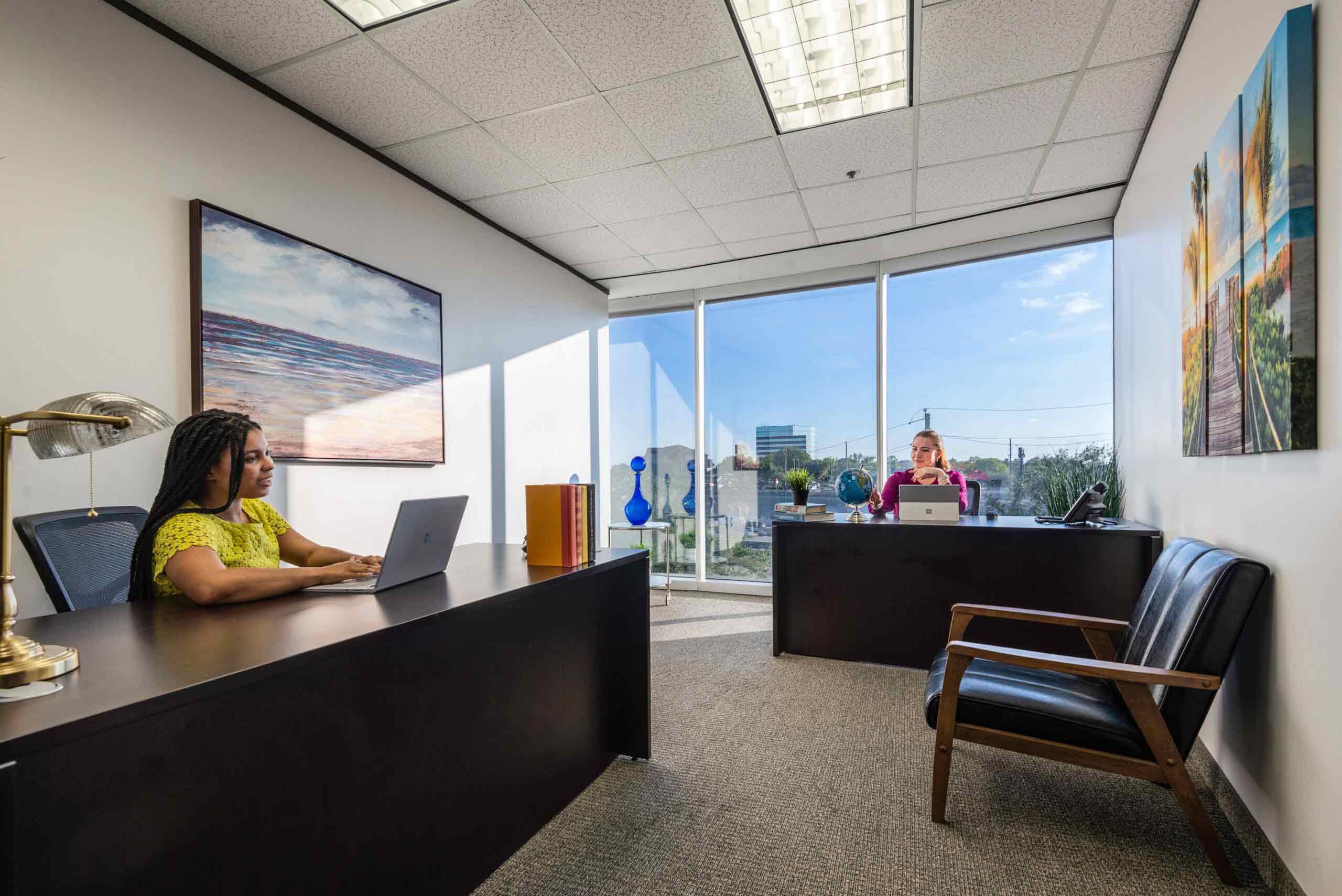 Large shared office space in North Dallas with floor to ceiling windows and natural light.