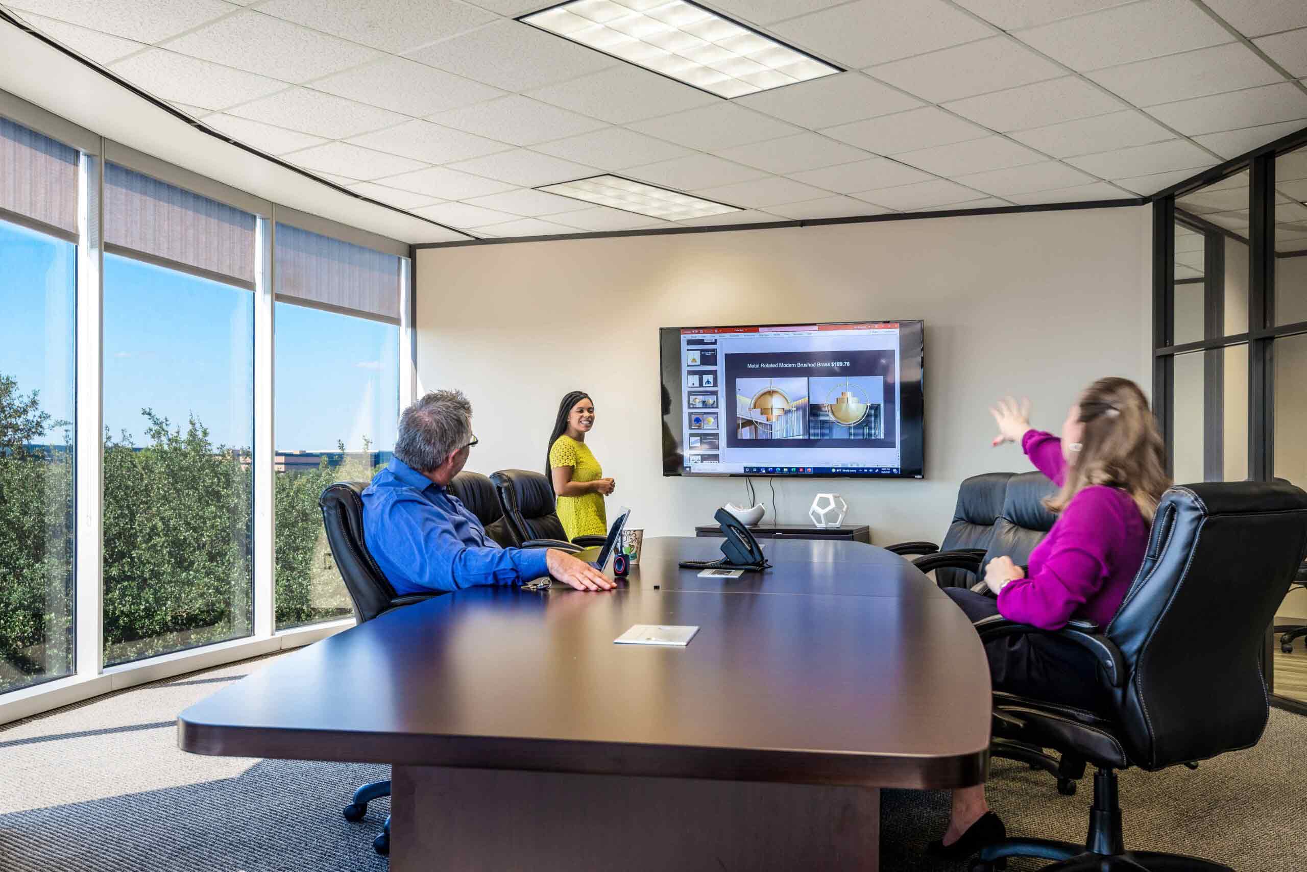 North Dallas meeting space with floor to ceiling windows, boardroom table, television, with natural light.