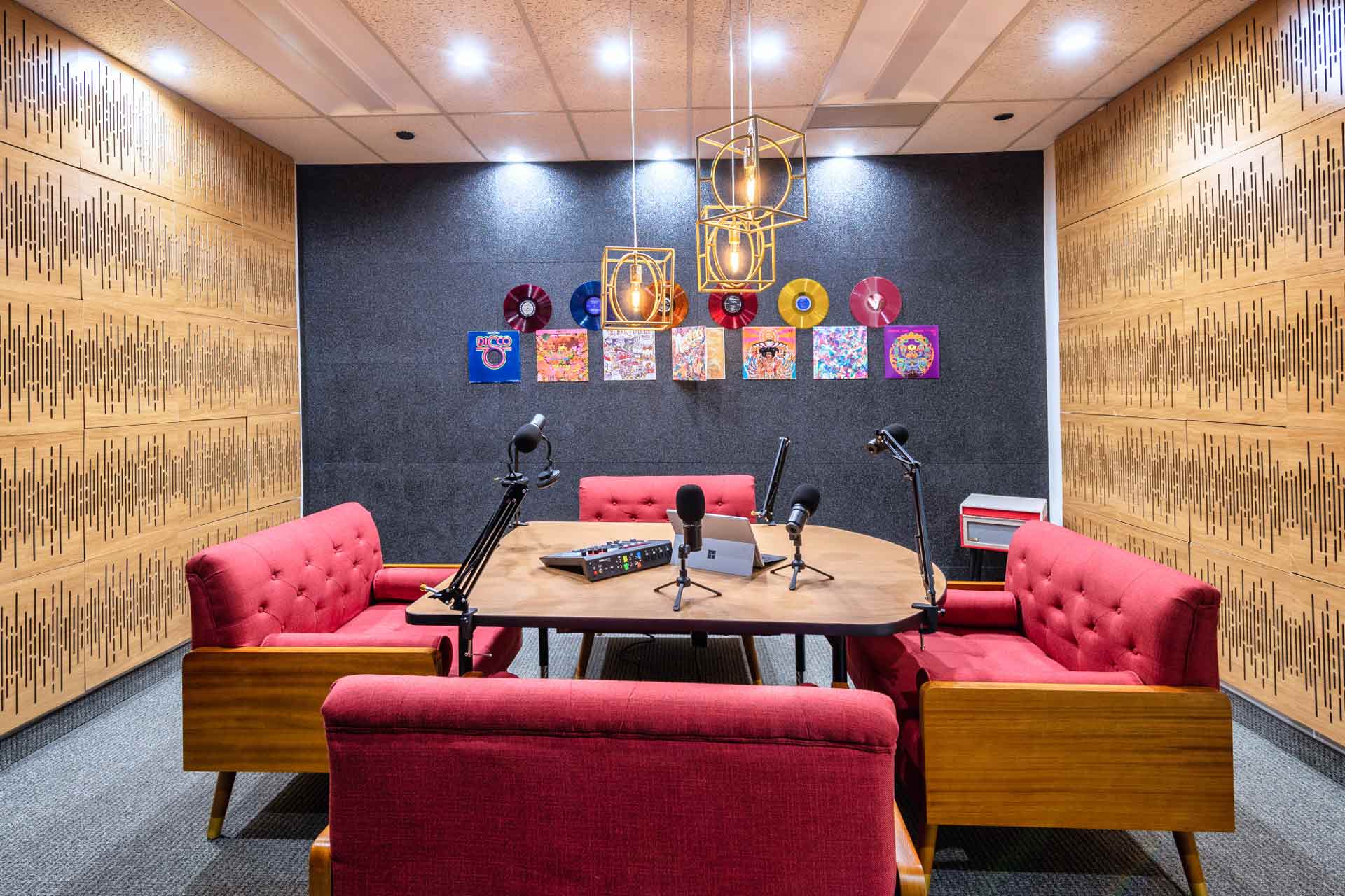 Podcast Room in CUBExec at Uptown Dallas. It has 4 red chairs and 4 mics.