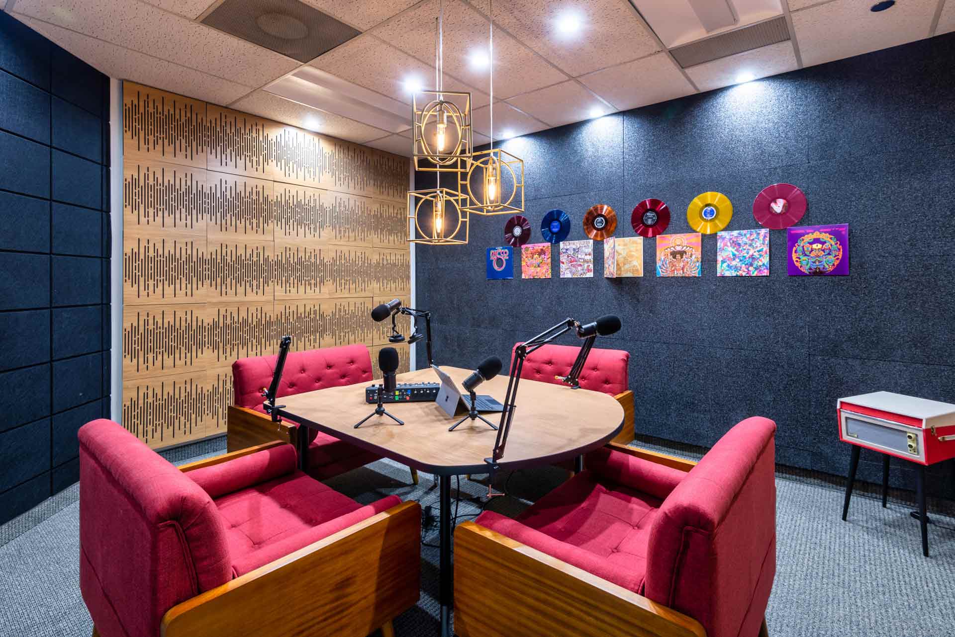 Podcast Room at Uptown Dallas with 4 sofa seats and mics. Soundproofing walls with dics cover decoration
