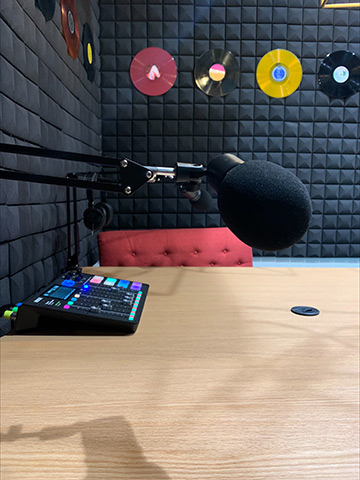 Close-up of microphone and mixing console in podcast room